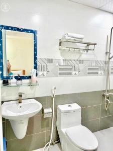 ブンタウにあるAn Khang Hotel Vung tauのトイレ、洗面台、鏡のあるバスルーム