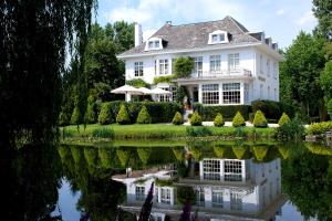 a white house with its reflection in the water at Hotel Hippocampus in Mol