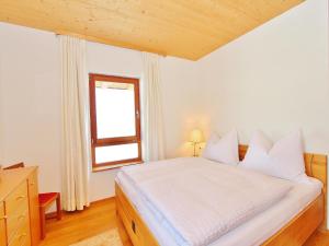 a bedroom with a white bed and a window at Chalet in St Johann by Ski Slope in Sankt Johann in Tirol