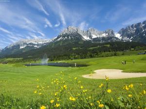 a golf course in a field with mountains in the background at Chalet in St Johann by Ski Slope in Sankt Johann in Tirol