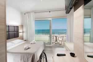 a bedroom with two beds and a balcony with the ocean at Hotel Bellevue in Cattolica +57 photos