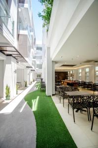 a cafeteria with tables and chairs and green grass at Boracay Haven Suites in Boracay
