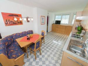 a kitchen and a living room with a table and a couch at Apartment in Tröpolach near Nassfeld Gondola in Tröpolach