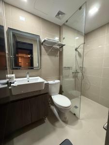 une salle de bain avec toilettes, lavabo et douche dans l'établissement 3 Bedroom Executive Suite Room with Excellent View of the City Skyline, à Manille 3 autres photos