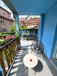 een terras met een tafel en stoelen op een balkon bij Lescapade à Colmar in Colmar