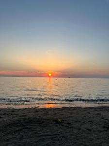 a sunset on the beach with the sun setting at Muli 1 Bedroom Apartment in (( Stan i Ri ))