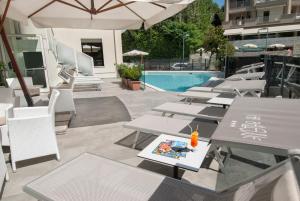 a group of tables and chairs next to a pool at Hotel Bellevue in Cattolica