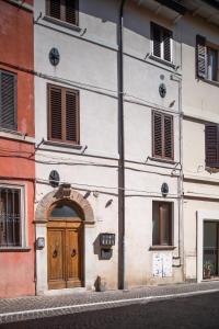 a building with a wooden door on a street at B-Suite Pesaro, Mare & Stile in Pesaro