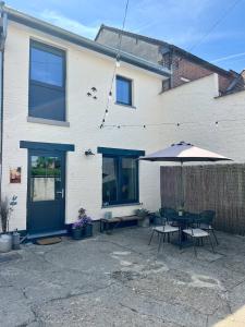 a patio with a table and an umbrella at La maison de MiLy in Bassenge