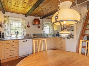 a kitchen with a wooden table and a large chandelier at 6 person holiday home in Læsø-By Traum in Læsø