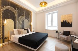 een slaapkamer met een groot bed en een stoel bij VillaNoa Luxury Stay in Cagliari