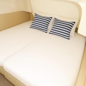 a bed with two blue and white striped pillows at Frognerstranda - Majestic- in Oslo