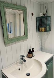 a bathroom with a white sink and a mirror at Classic Danish Holiday Home in Karrebæksminde +31 photos