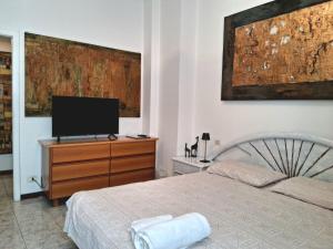 a bedroom with a bed and a television on a dresser at Central Art House in Como