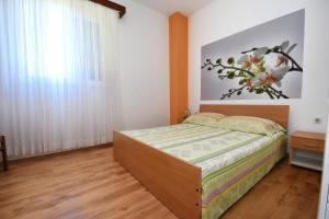 ein Schlafzimmer mit einem Bett und einem großen Fenster in der Unterkunft Apartments Ella in Poreč