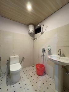 a bathroom with a toilet and a sink at Mount Valley Martolia Resort in Joshīmath