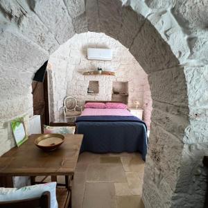 a bedroom with a bed in a stone wall at Trullo Incanto in Ostuni