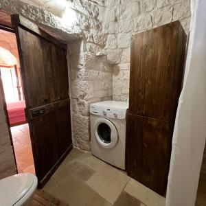 a washer and dryer in a stone bathroom at Trullo Incanto in Ostuni