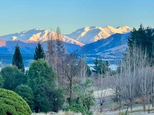 a mountain range with snow capped mountains in the distance at Mitchella Eco Stay in Wanaka +24 photos