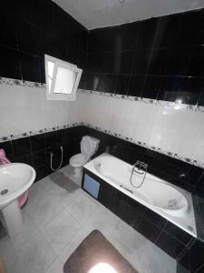 a bathroom with a tub and a toilet and a sink at STUDIO Calm House in Sousse