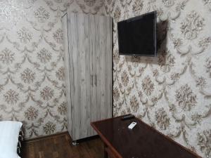 Zimmer mit einem TV an der Wand und einem Tisch in der Unterkunft GUEST HOUSE Silver1 in Samarkand