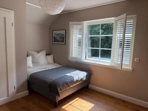 a bedroom with a bed and a window at Das besondere Ferienhaus nähe Nürburgring in Lückenbach