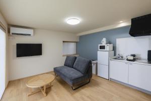 a living room with a chair and a kitchen at 喜々Kiki in Miyazu +82 photos