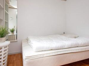 a white bed in a room with a mirror at 2 person holiday home in Gråsten in Gråsten