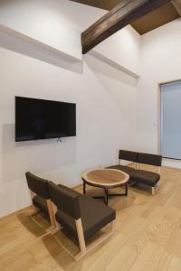 a living room with a tv and a table and chairs at 喜々Kiki in Miyazu