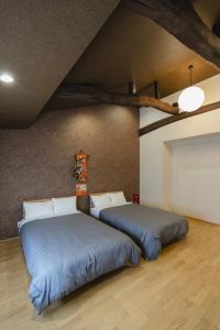 two beds in a room with blue sheets at 喜々Kiki in Miyazu