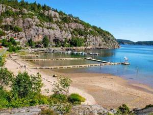 a beach with a dock and boats in the water at 6 person holiday home in MUNKEDAL in Munkedal