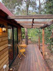 a wooden deck with a table and chairs on a cabin at Rancho Relaxo Tiny House - in town sanctuary in Margaret River Town