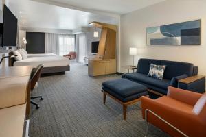 a hotel room with a bed and a living room at Courtyard by Marriott St. Louis St. Peters in Saint Peters