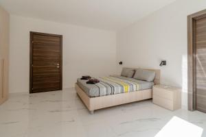 a bedroom with a bed and a wooden door at Luqa 3 bedroom penthouse T in Luqa