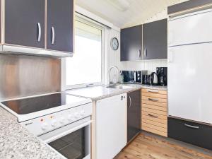 a kitchen with white appliances and a window at 6 person holiday home in Løkken-By Traum in Nørre Lyngby +21 photos
