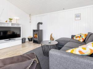 a living room with a couch and a fireplace at 6 person holiday home in Løkken-By Traum in Nørre Lyngby