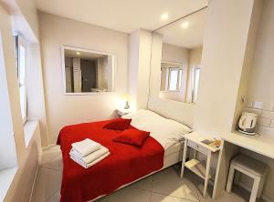 a small bedroom with a red blanket on a bed at Mirror Apartments in Kraków