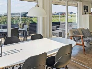 a dining room with a white table and chairs at 6 person holiday home in Løkken-By Traum in Nørre Lyngby