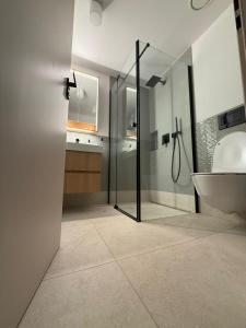 a bathroom with a shower and a tub and a sink at Chata Milde in Nový Hrozenkov
