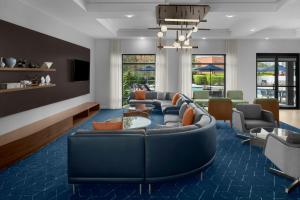 a living room with a blue couch and chairs at Courtyard Fort Lauderdale East Lauderdale-by-the-Sea in Fort Lauderdale