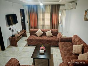 a living room with two couches and a tv at EVANNA SUITE AND HOTELs ايفانا للشقق الفندقيه و المفروشه in Amman +13 photos