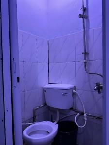 a small bathroom with a toilet and a hose at THE AUTOGRAPH Bases Hotel in Hausa