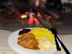 a plate of food with meat and rice on a table at Tlou Tribal Lodge in Pilanesberg