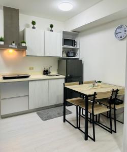a kitchen with a table and a black refrigerator at Affordable Boracay-like Staycation in Azure South in Manila