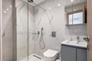 Un baño con ducha, inodoro y lavabo. en Icon Luxury Apartments, en (( Kermetés ))