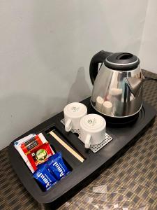 Una bandeja negra con una tetera y otros artículos encima. en Chandra Residency Banaras, en Varanasi
