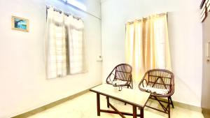 two chairs and a table in a room at Waves Seafront home in Cochin