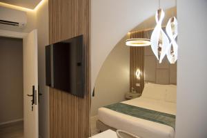 a bedroom with a bed and a flat screen tv at The Three Diamonds - B&B CESENATICO in Cesenatico