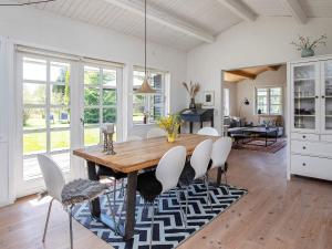 eine Küche und ein Esszimmer mit einem Holztisch und Stühlen in der Unterkunft 8 person holiday home in Væggerløse in Bøtø By