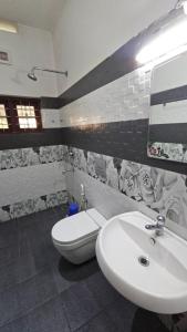 a bathroom with a white sink and a toilet at ThekkadyPknhomes in Thekkady +30 photos